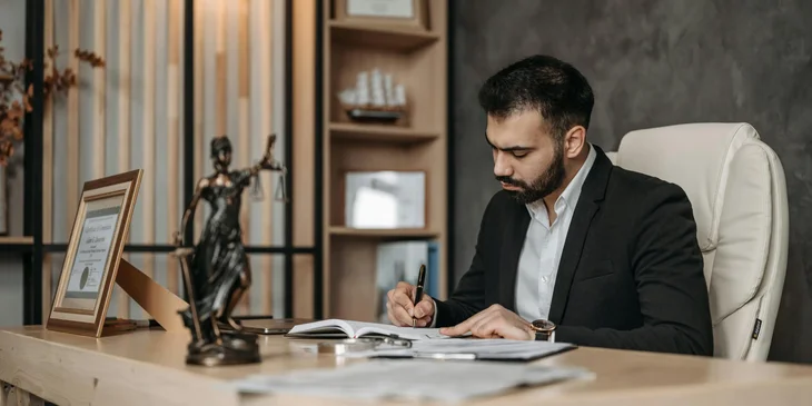 A criminal lawyer drafting some legal documents to be presented at court.