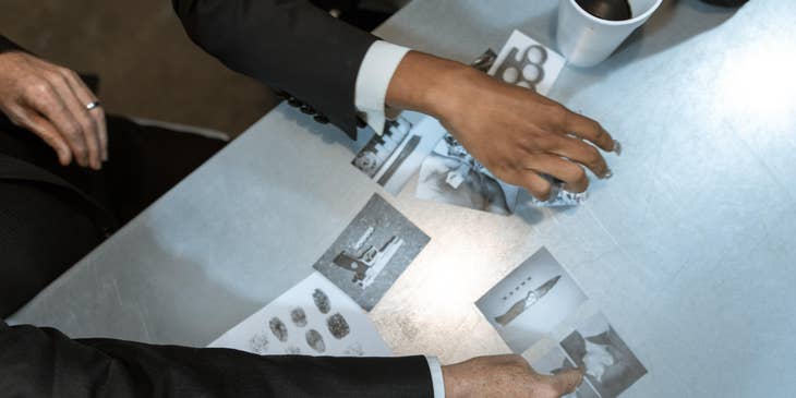 A Criminologist showing and explaining pictures of evidences gathered in a crime scene to law enforcer.