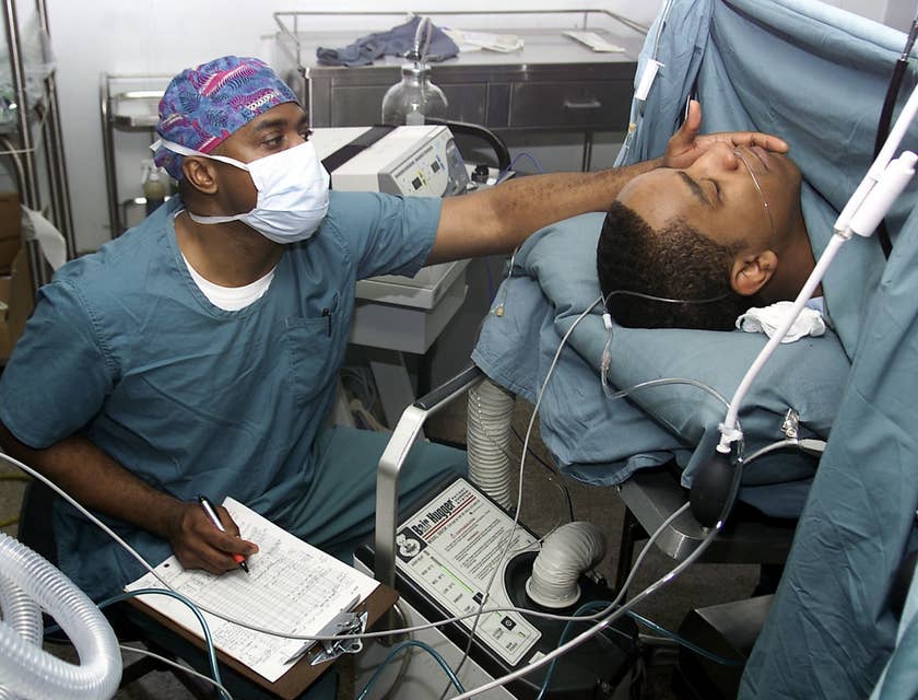 Certified Registered Nurse Anesthetists monitor the patient during a medical procedure.