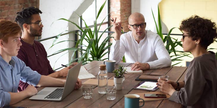 CTO deliberating with his team and sitting inside the conference room