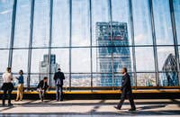 Un hombre caminando frente a una ventana de vidrio.