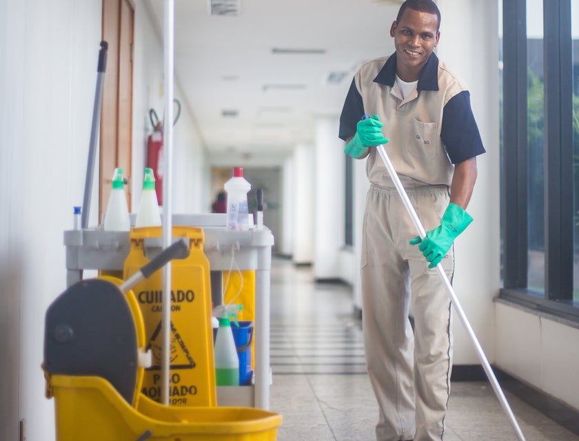 Custodian cleaning a hallway in a building