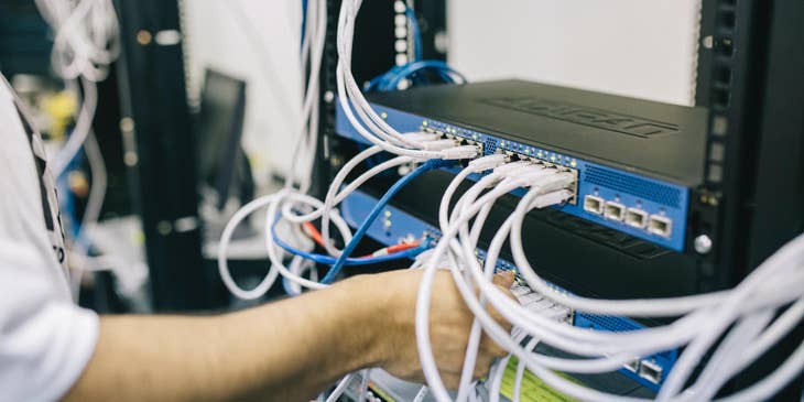 Data Center Technician inserting the cords on server slots as part of the routine maintenance check