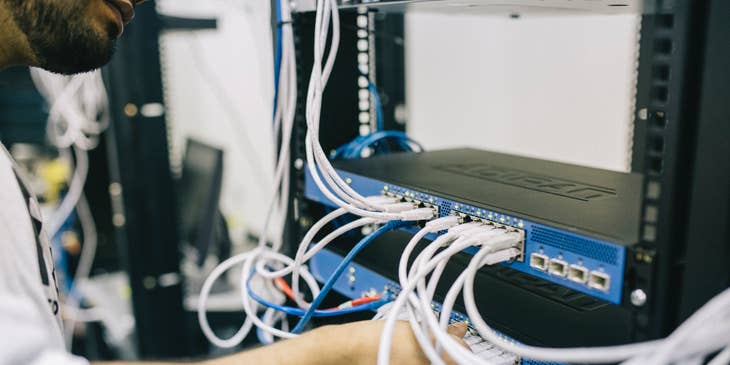 Data Center Technician inserting the cords on server slots as part of the routine maintenance check