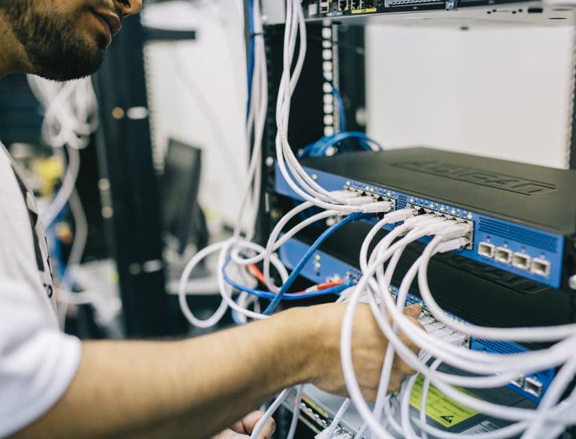 Data Center Technician inserting the cords on server slots as part of the routine maintenance check