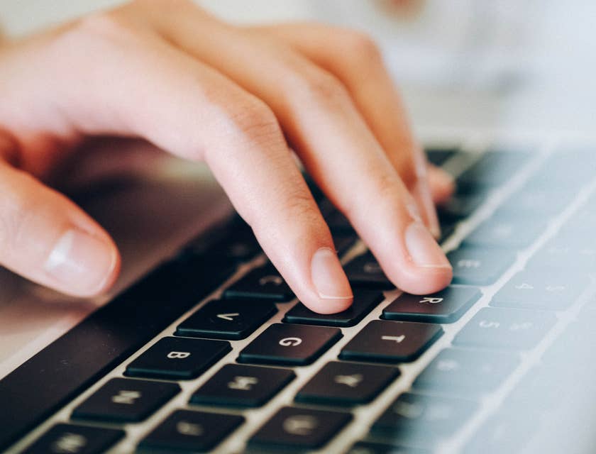 A person typing on a keyboard and entering data into a computer.
