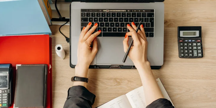 A data entry specialist maintaining a digital filing system on a laptop.