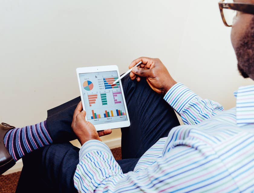 Data Quality Analyst holding a tablet and looking at the details of a data analytics report
