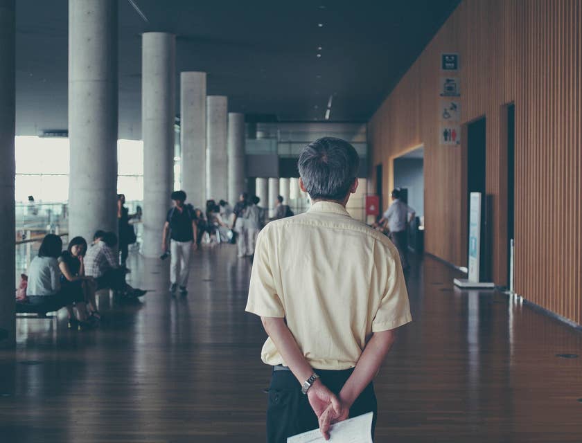 Dean of Students watching a group of students in the hallway while holding a piece of paper