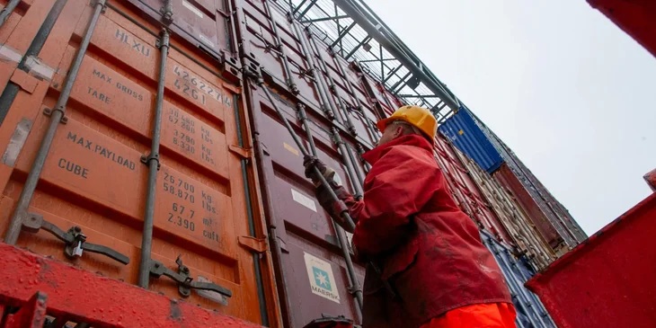 A deckhand securing the cargo containers.