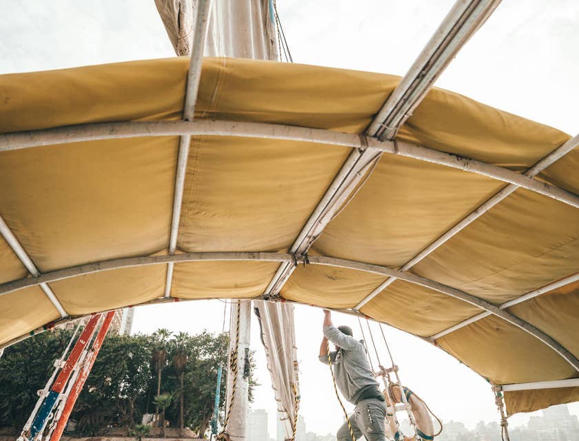 Deckhand adjusting sails on a boat