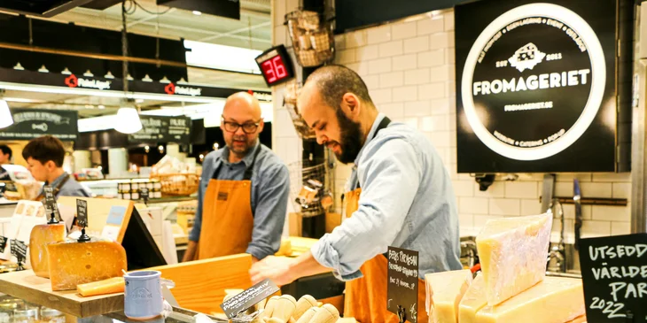 A deli clerk preparing cheese.