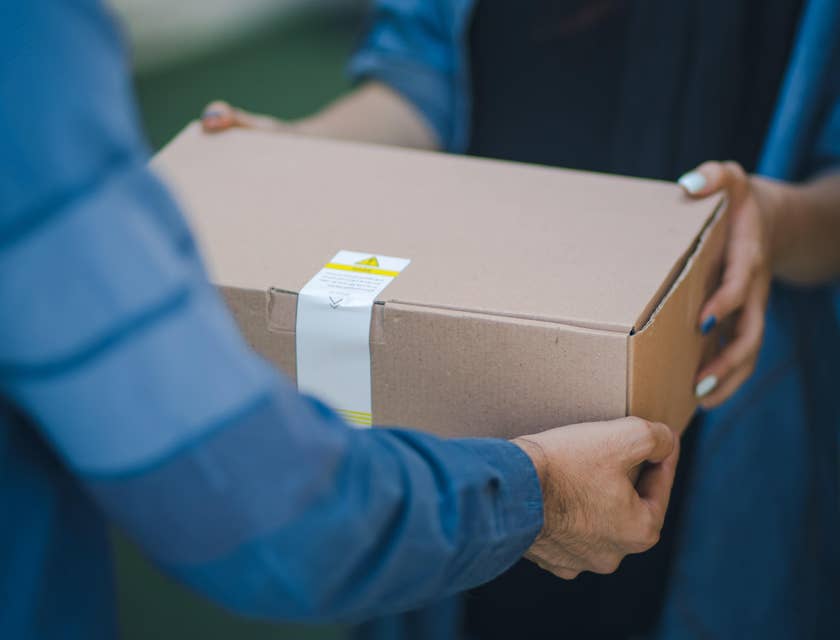 A Delivery boy on duty handing over a package to a female client.