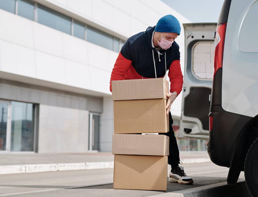 A Delivery Driver loading packages into a company vehicle and about to transport them to the clients.