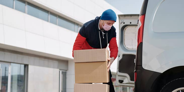 A Delivery Driver loading packages into a company vehicle and about to transport them to the clients.