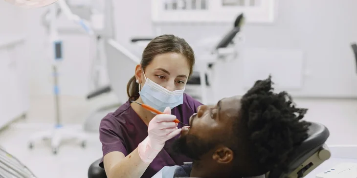 A dental hygienist examining a patient's teeth.