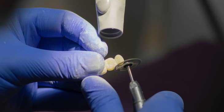 Dental Laboratory Technician polishing dental prostheses.