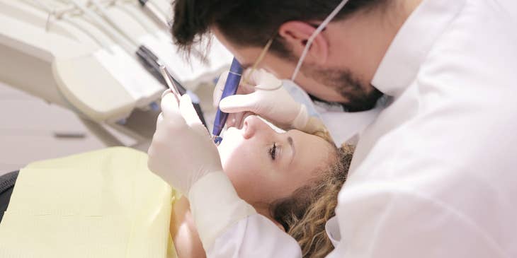 The dentist performing tooth extraction.