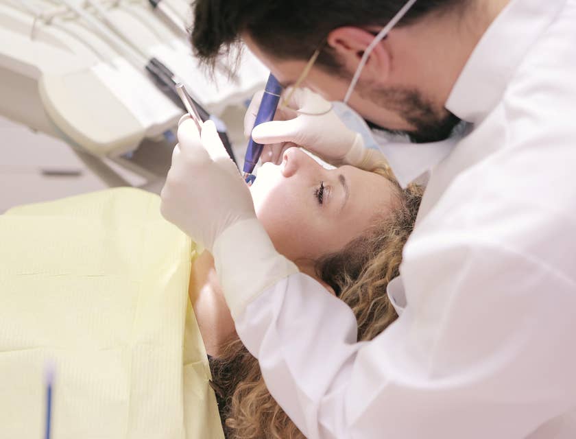 The dentist performing tooth extraction.