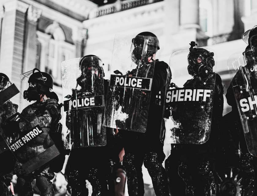 Deputy Sheriff wearing full protective gear and shield while on-duty at a high alert area with the rest of the team