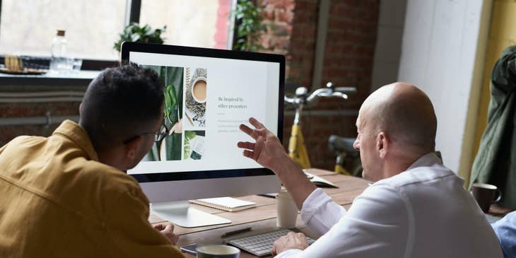 young Digital Designer presenting his final product with his client while he gives him feedback regarding the design
