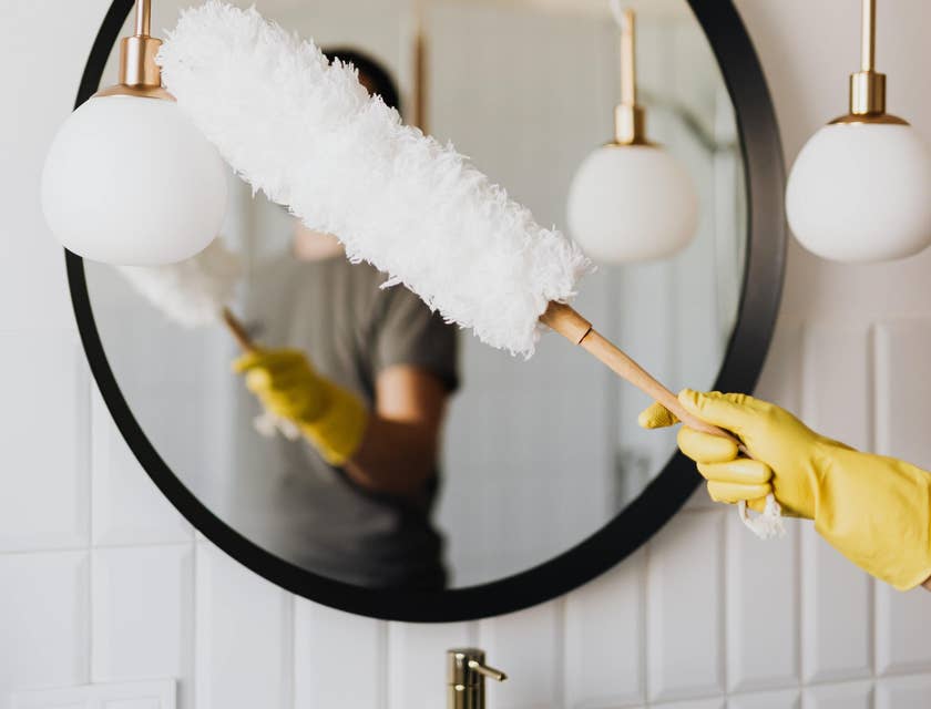 Domestic Helper dusting a lighting fixture