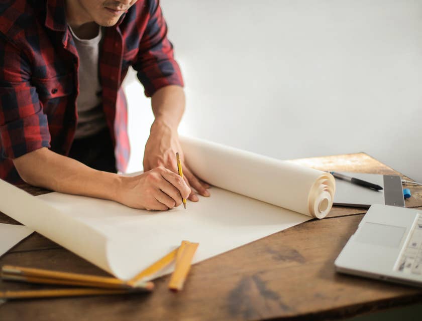 Draftsman draws plan on his blueprint working on a new design