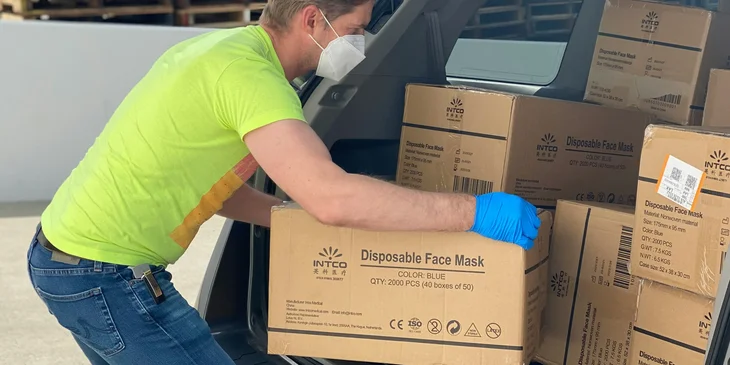 A driver helper loading packages into a delivery vehicle.
