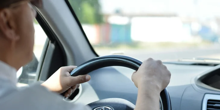 A driver driving around the city about to pick up a client from a hotel.