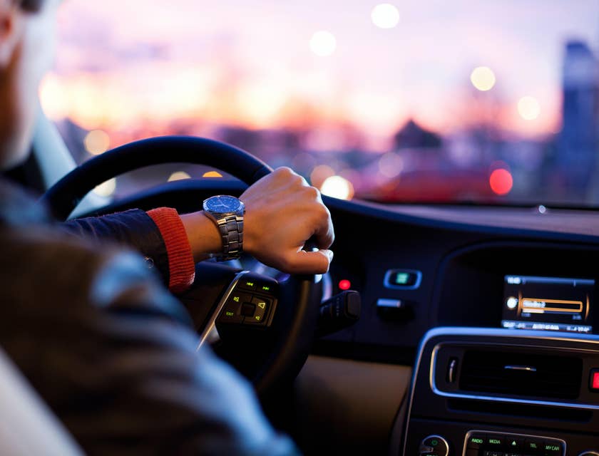 A Driver driving around the city about to pick up a client from a hotel.