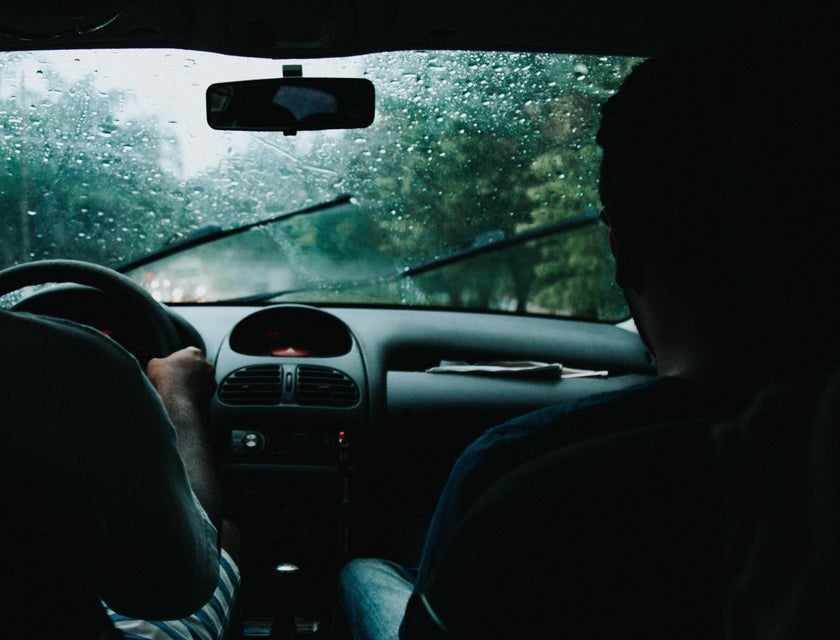 Driving instructor teaches a new driver how to control the car safely when raining