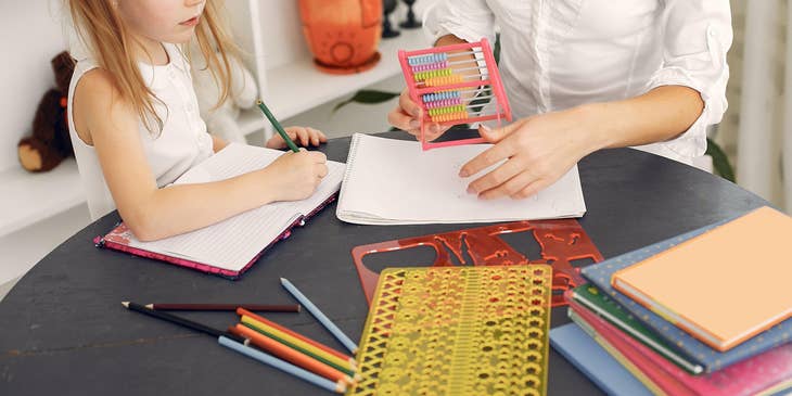 Early childhood educator teaches a student how to count using an abacus