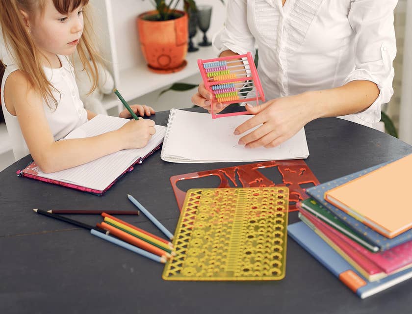 Early childhood educator teaches a student how to count using an abacus