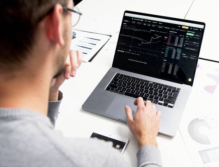 male Economist looking at the chart report on his laptop