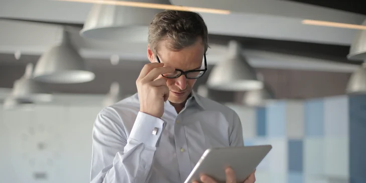 An editor in chief reviewing an article on a tablet.