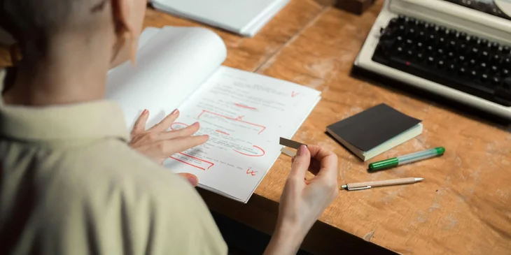 A female editor reviewing and proofreading a script.