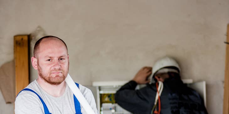 Electrician apprentice repairing a panel board with under the instructions of an electrician