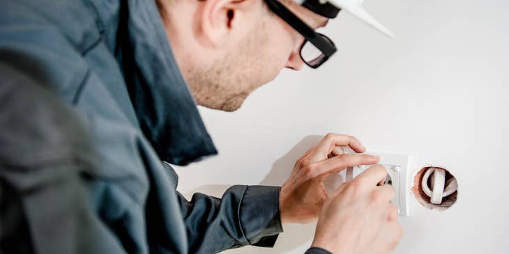 Electrician repairing an electrical outlet