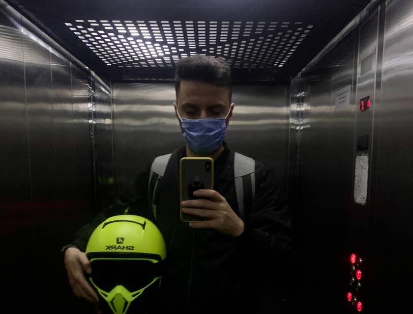 man with a mask on in an elevator