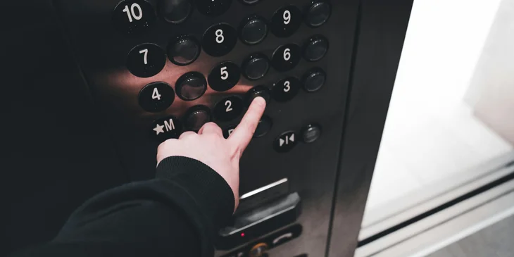An elevator mechanic inspecting the elevator buttons.