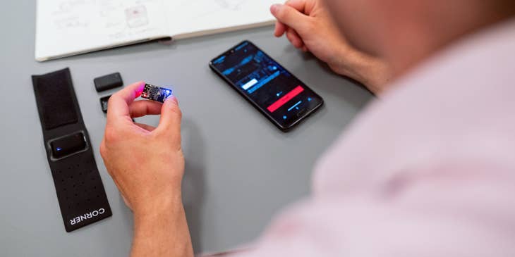 Embedded Software Engineer holding a chip to be installed on a smartphone with a compatible app installed as part of the final testing
