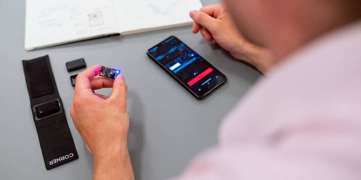 Embedded Software Engineer holding a chip to be installed on a smartphone with a compatible app installed as part of the final testing