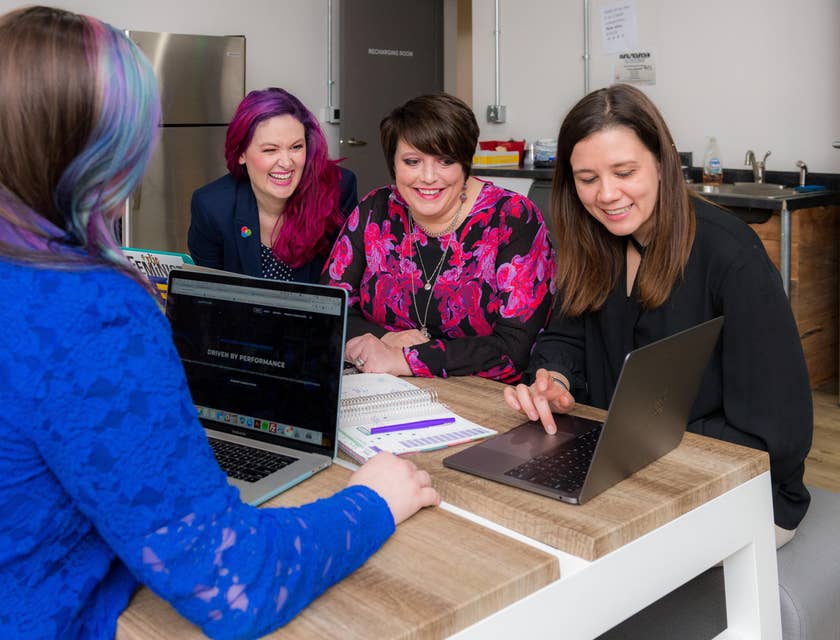 female Engagement Manager presenting details from her laptop to the client's team inside the office room