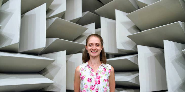 female Engineer smiling and standing behind her own architectural design