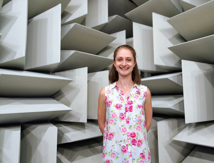 female Engineer smiling and standing behind her own architectural design