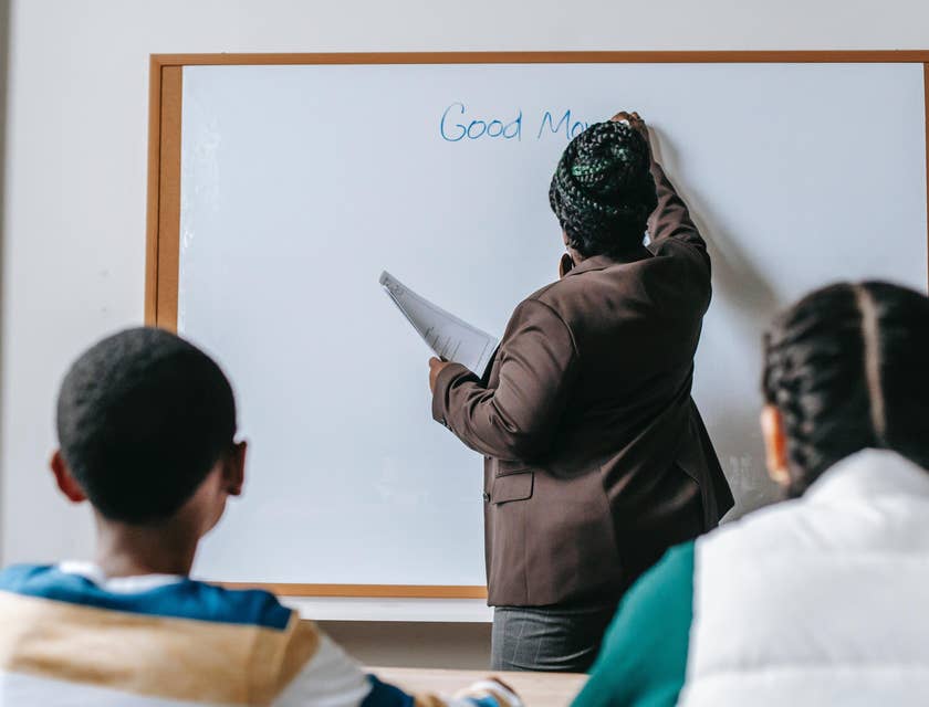 English Teacher starts the class by writing something on the board for the students to read