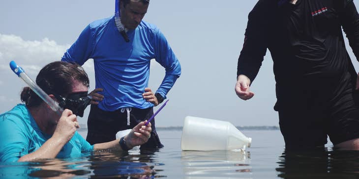 a team of Environmental Specialists collecting a water sample for testing purposes.