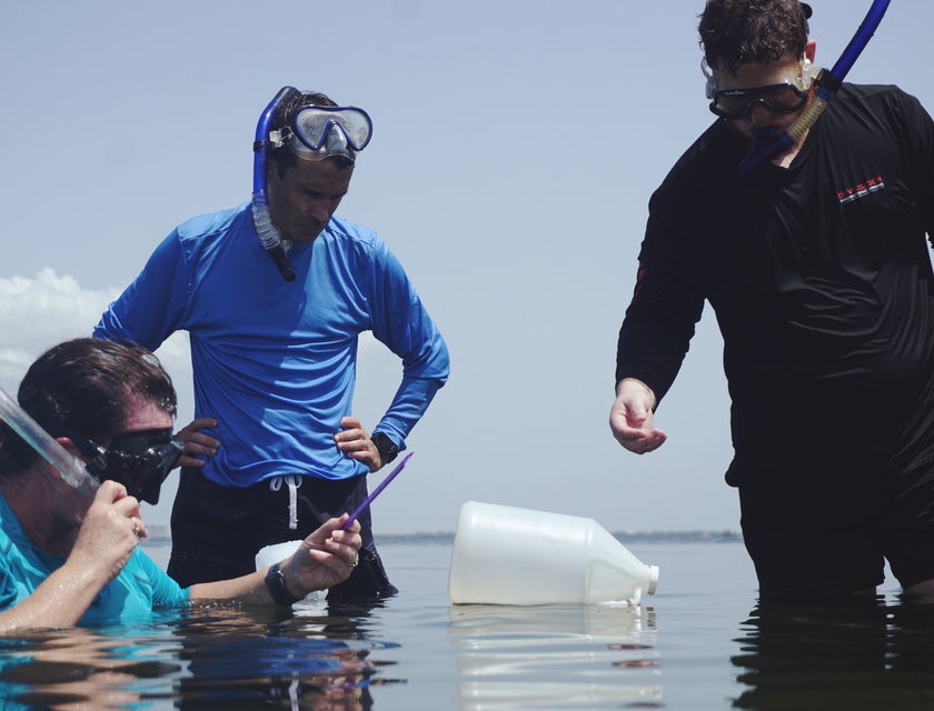a team of Environmental Specialists collecting a water sample for testing purposes.