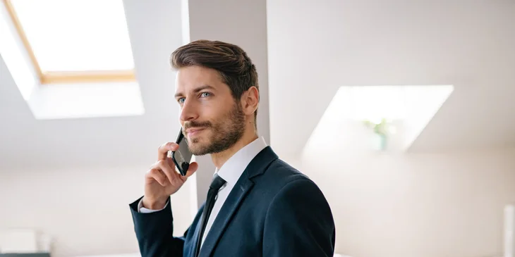 An executive director in a suit on a phone call.