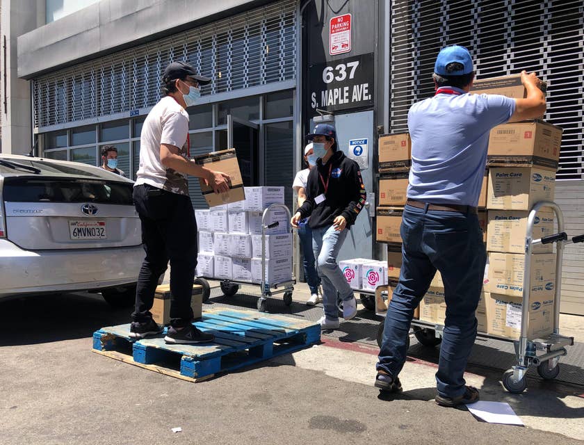 An Expeditor wearing black sweat shirt outside a warehouse receiving and about to examine deliveries.